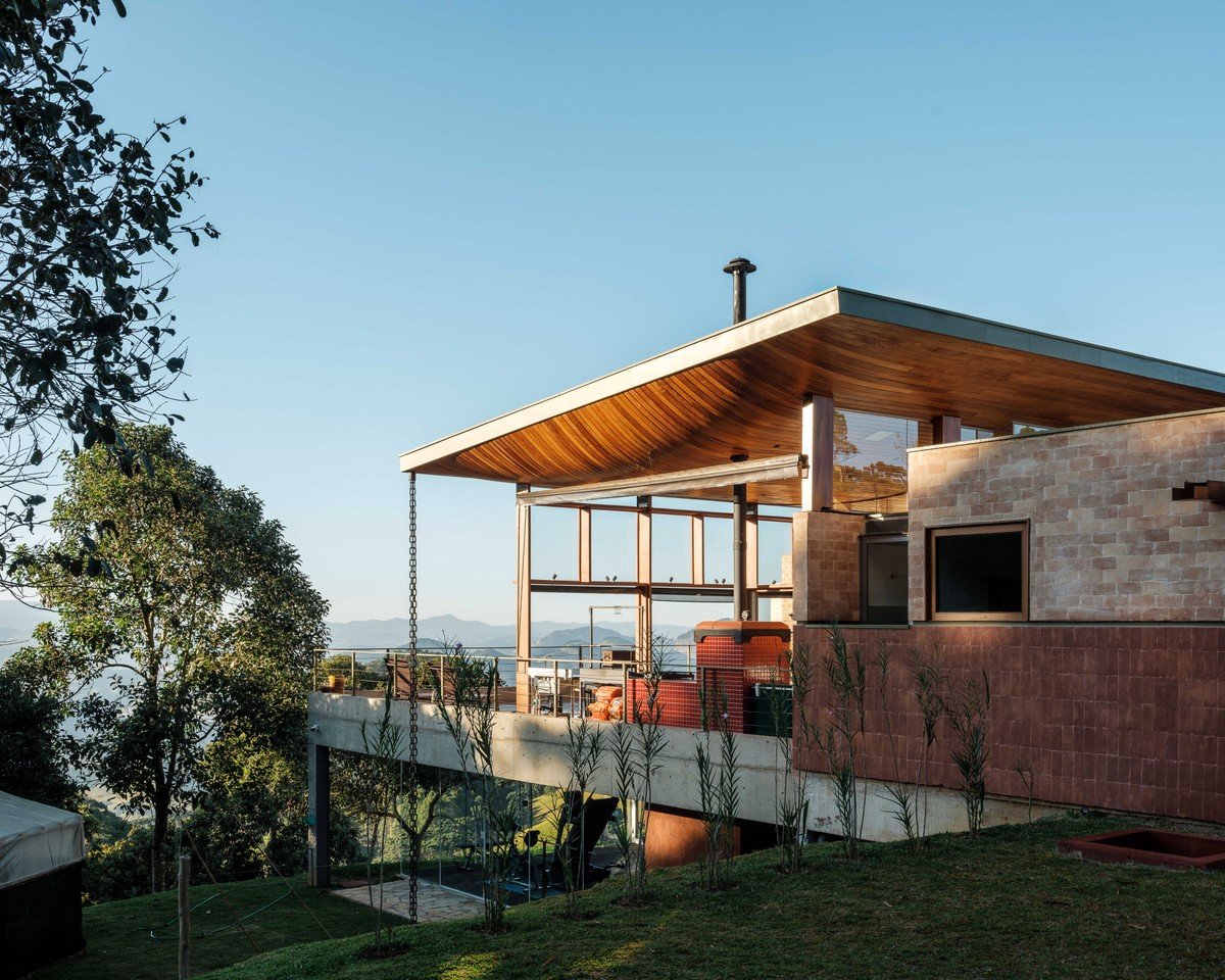 Casa une madeira, cerâmica, concreto e outros materiais na Serra da Mantiqueira